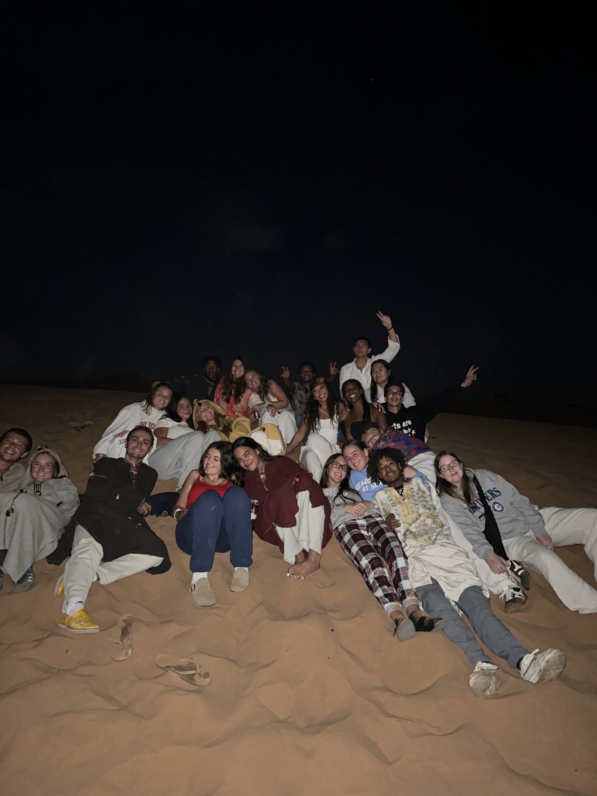 Travelers gathered on the Sahara dunes at night