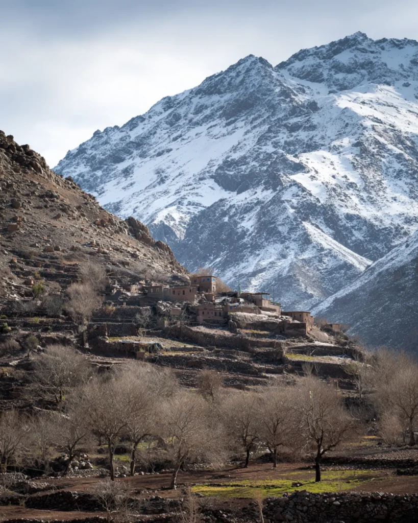 Berber village on terraced slopes below the snowy High Atlas peaks near Imlil