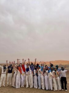 Student group celebrating on the Sahara dunes in Merzouga