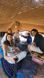 Travelers relaxing inside a Berber nomad tent in the Sahara