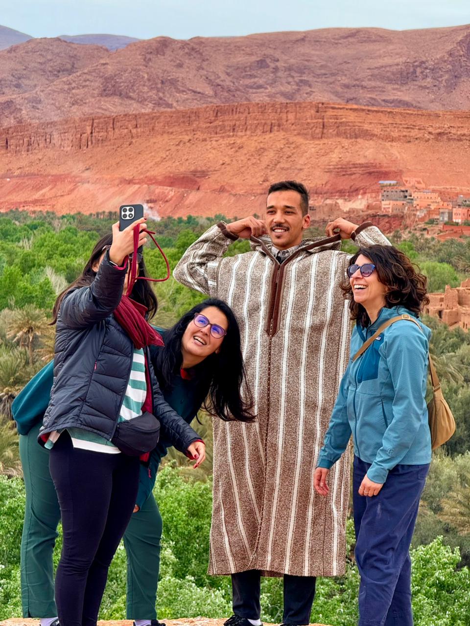 Guide in a traditional djellaba with travelers in the Dades Valley