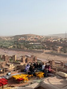 Travelers on a rooftop terrace overlooking Ait Ben Haddou