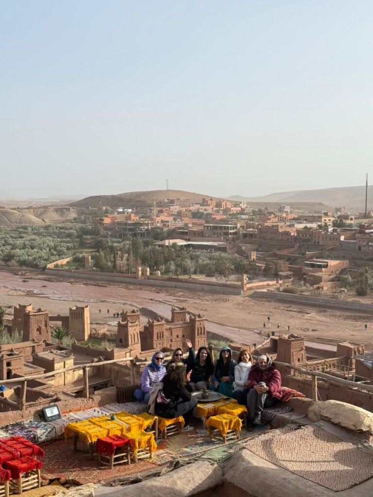 Travelers on a rooftop terrace overlooking Ait Ben Haddou