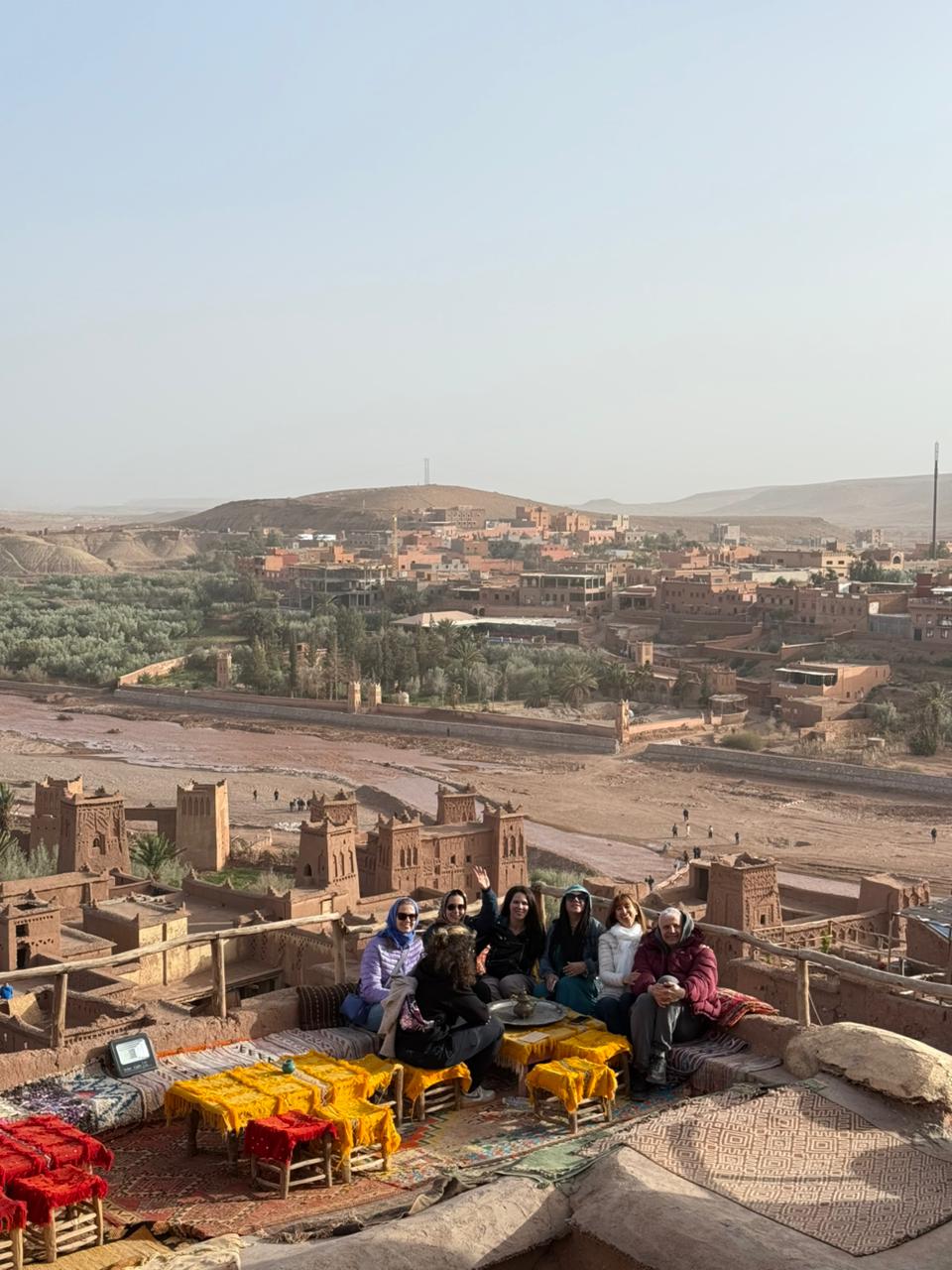 Travelers on a rooftop terrace overlooking Ait Ben Haddou