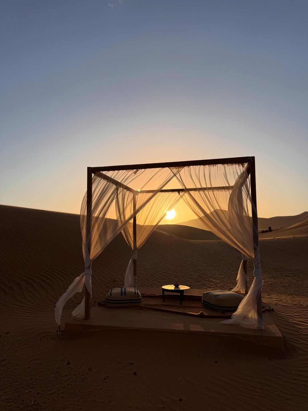 Luxury desert camp canopy at sunset in the Merzouga dunes