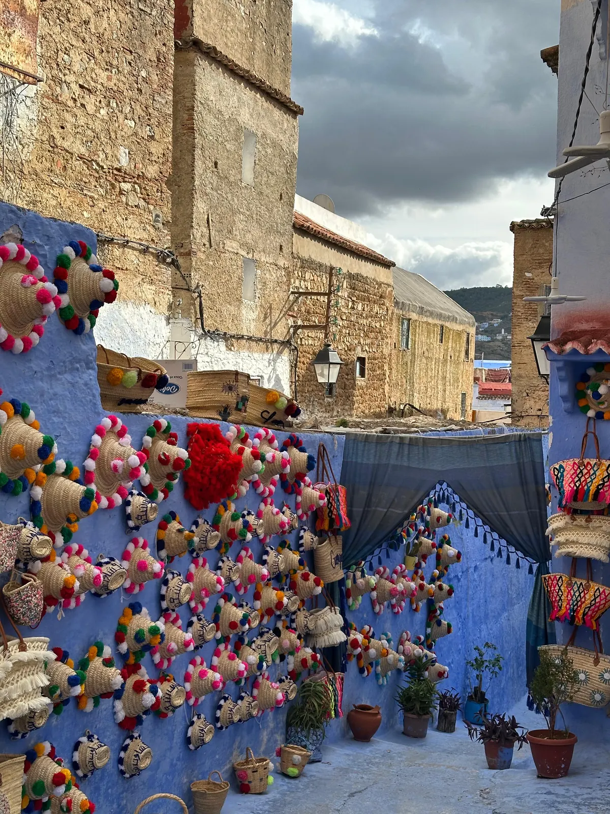 Blue street with hanging crafts in the Chefchaouen medina