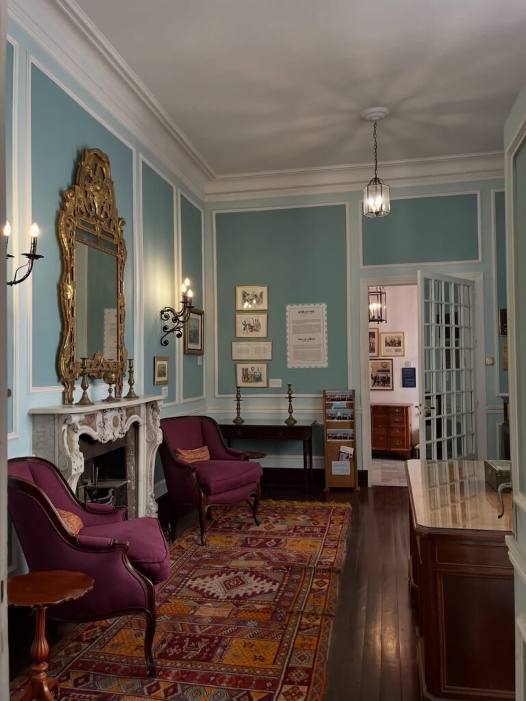 Historic blue salon with a gilded mirror and Moroccan carpet inside the Tangier American Legation