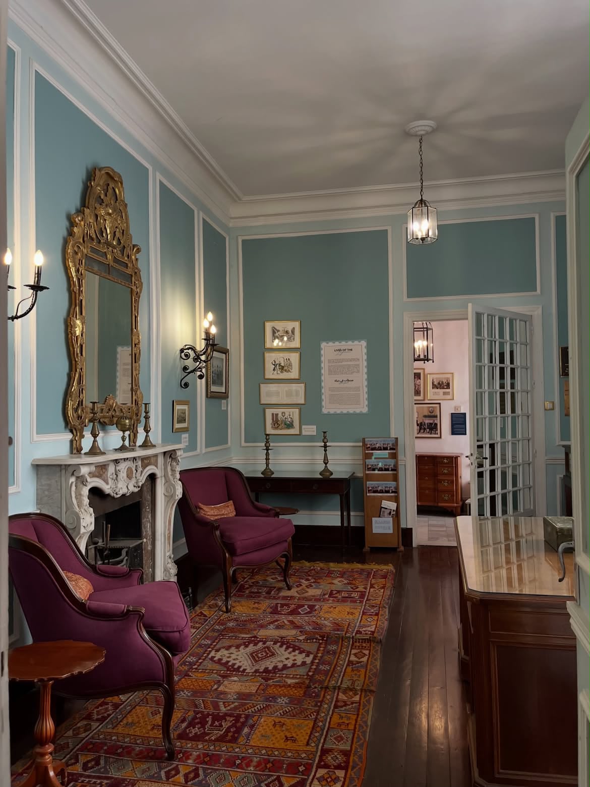 Historic blue salon with a gilded mirror and Moroccan carpet inside the Tangier American Legation