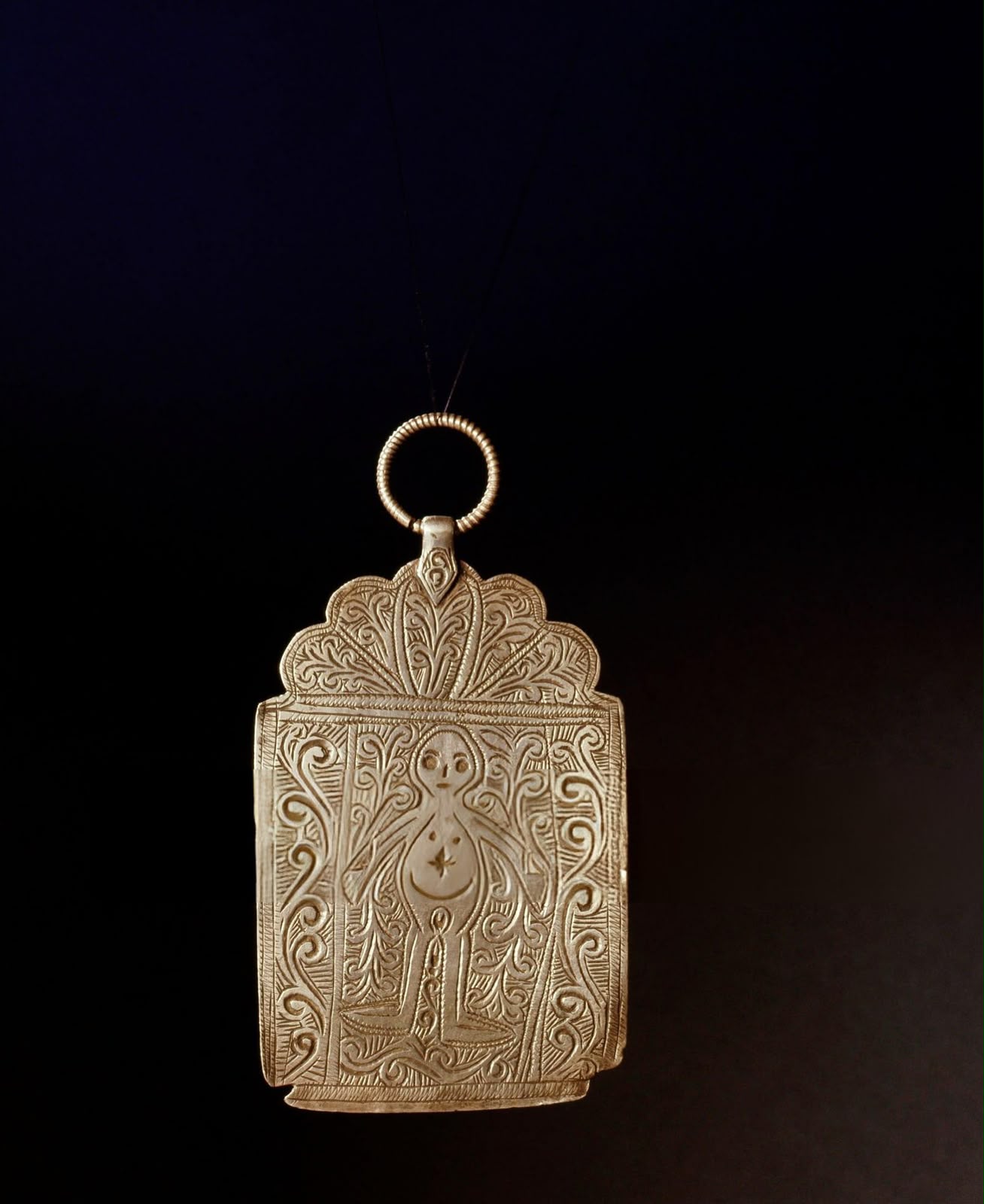 Engraved silver amulet pendant with a figure and floral patterns