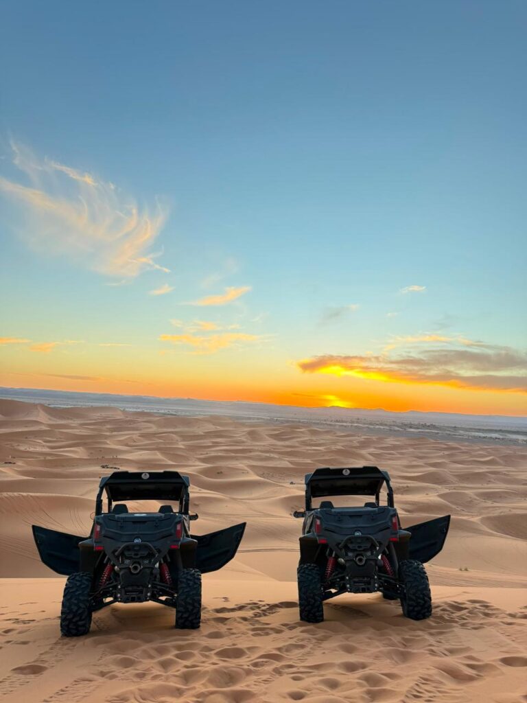 Two buggies parked on a dune at sunset in Merzouga, Morocco