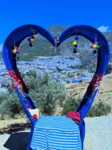 Marco azul en forma de corazón con vista a Chefchaouen desde un mirador