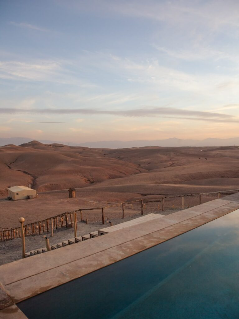 Infinity pool overlooking the Agafay Desert hills at sunset