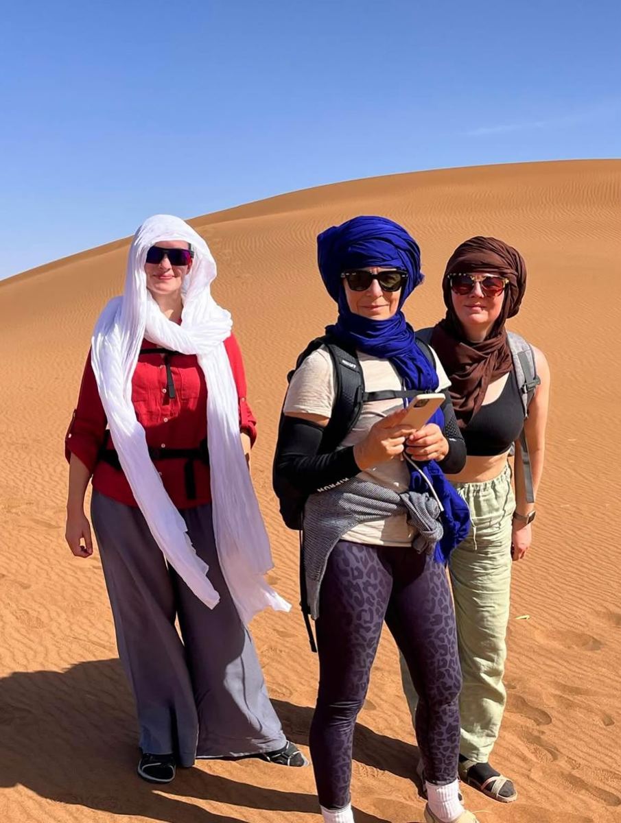 Travelers wearing desert scarves among the Sahara dunes