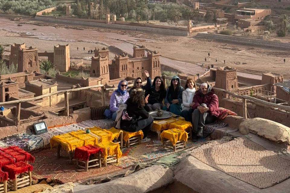 Travelers relaxing at a rooftop cafe overlooking Ait Ben Haddou